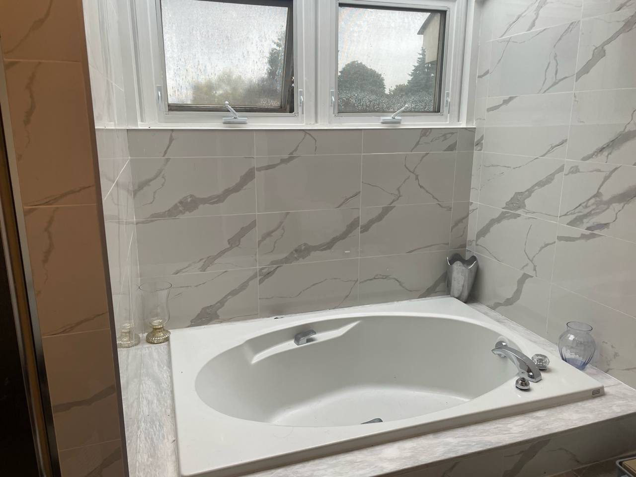Marble-look tile wall with window detail in a Reno Island bathroom renovation