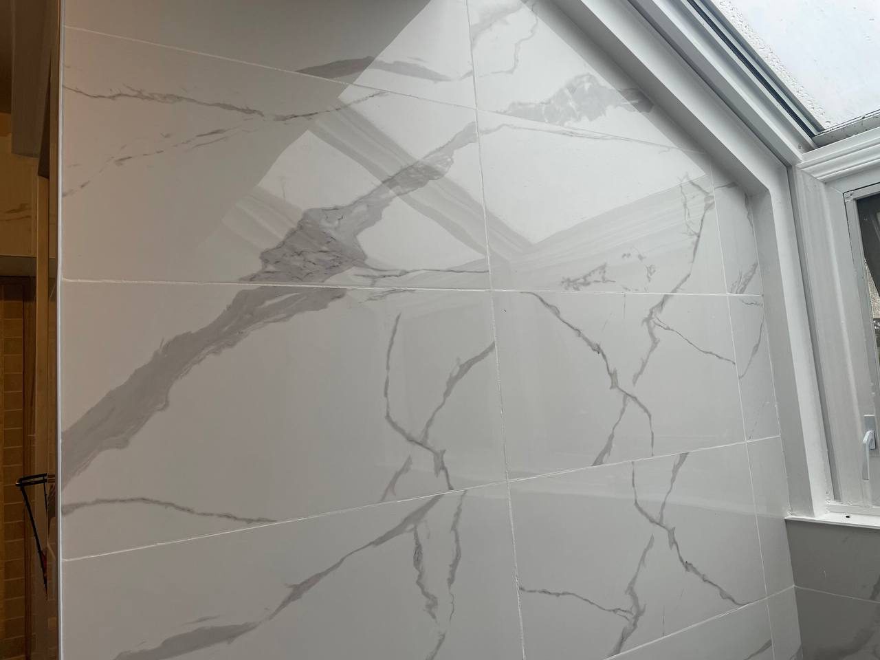 New bathtub surrounded by marble-look tile in a Reno Island bathroom renovation